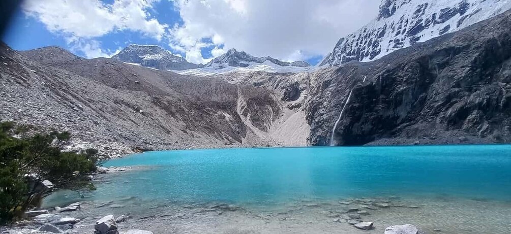A turquoise lake surrounded by rocky mountains and snow-capped peaks. 5