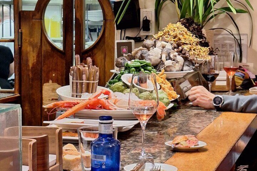 A seafood platter with shrimp, a bottle of blue sauce, and a martini glass. 1