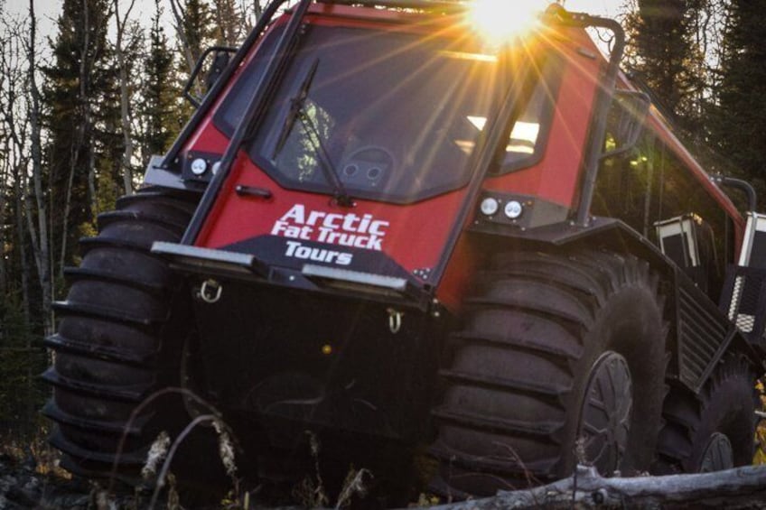 A red off-road vehicle with large tires and the text "Arctic Fat Truck Tours" on the front. 1