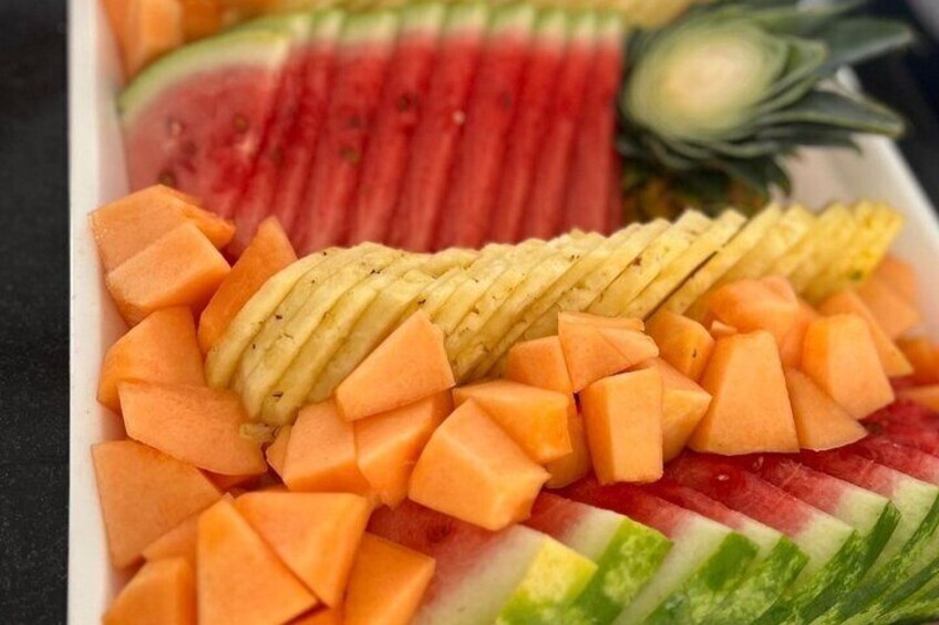 A tray of sliced watermelon, cantaloupe, and pineapple. 2