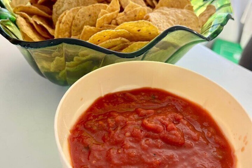 A bowl of salsa and a bowl of tortilla chips. 3