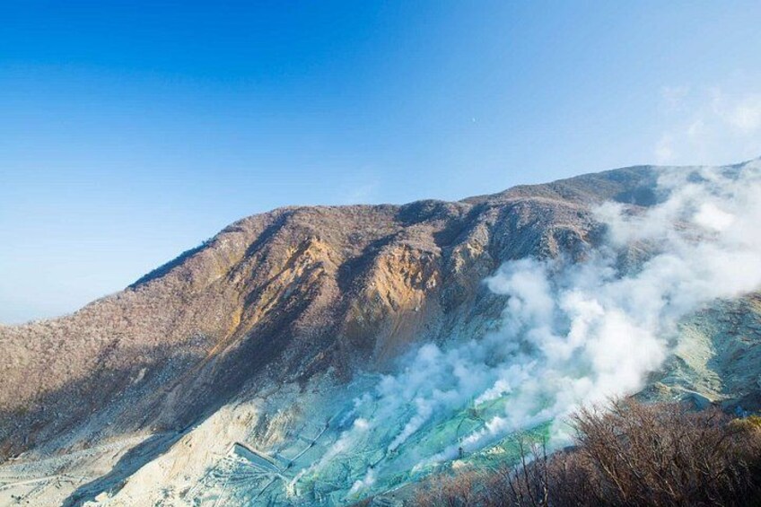 A mountain with steam rising from its base, indicating geothermal activity. 5