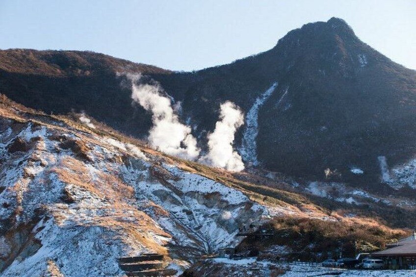 A snow-covered mountain with steam rising from its peak, indicating geothermal activity. 2