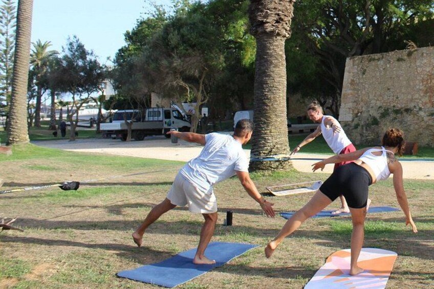People practicing yoga outdoors on mats. 3