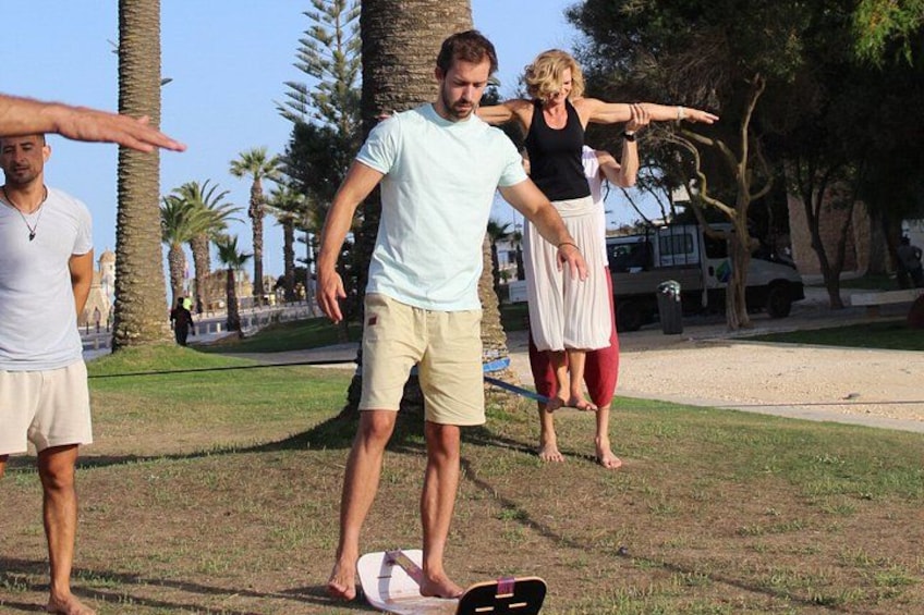 Personas practicando yoga al aire libre con palmeras y un cielo despejado de fondo. 3