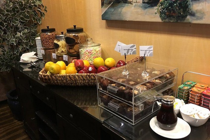 A buffet table with various food items, including fruits, pastries, and condiments. 3