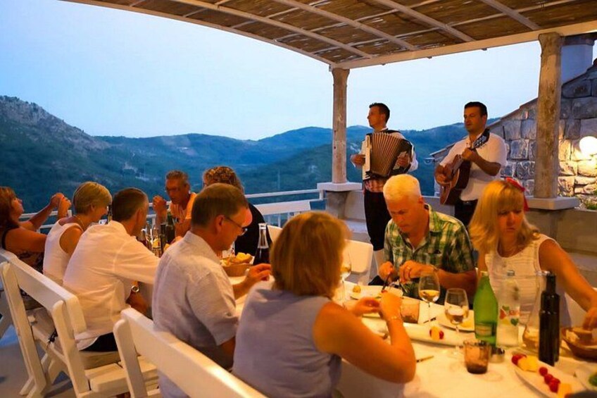 Des personnes dînent dans un restaurant en plein air, avec une vue imprenable sur les montagnes en arrière-plan. 3