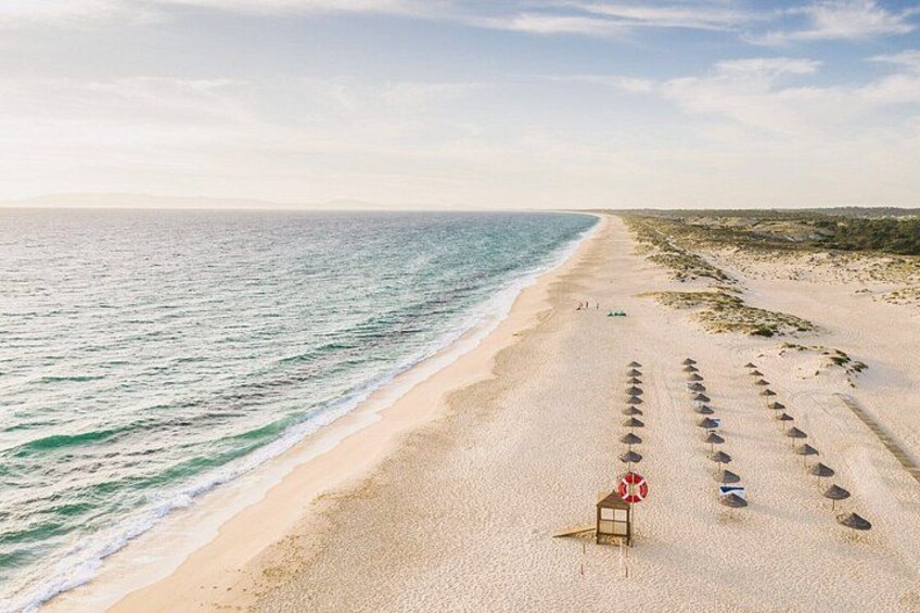 A beach with footprints leading to a lifeguard stand. 2