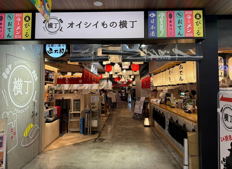 A Japanese store with a sign reading 'Oishimono no Yokocho'. 1