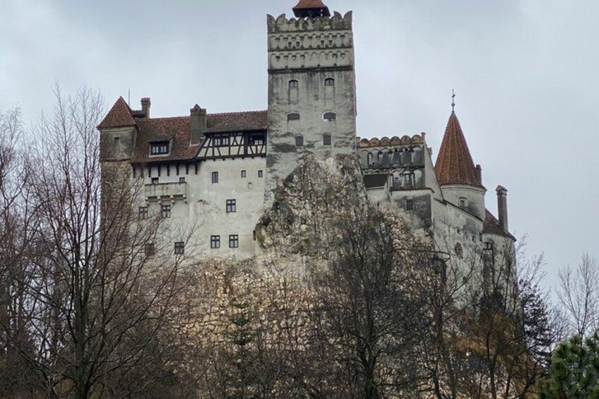 A historic castle with a prominent tower, steep walls, and a red-tiled roof. 2