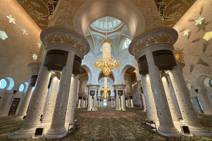 An interior with columns, a chandelier, and patterned walls. 5