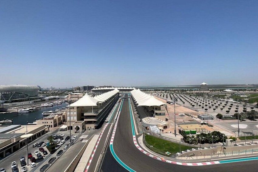 A racetrack with grandstands, a bridge, and a marina. 3