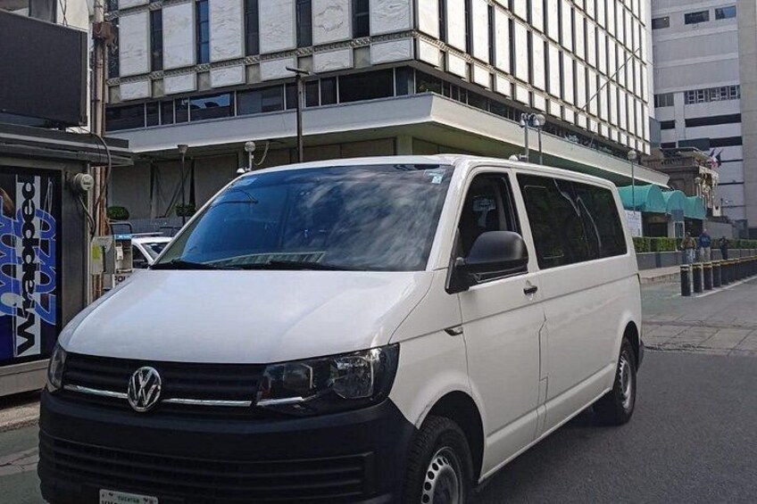 A white Volkswagen van parked on a city street. 2