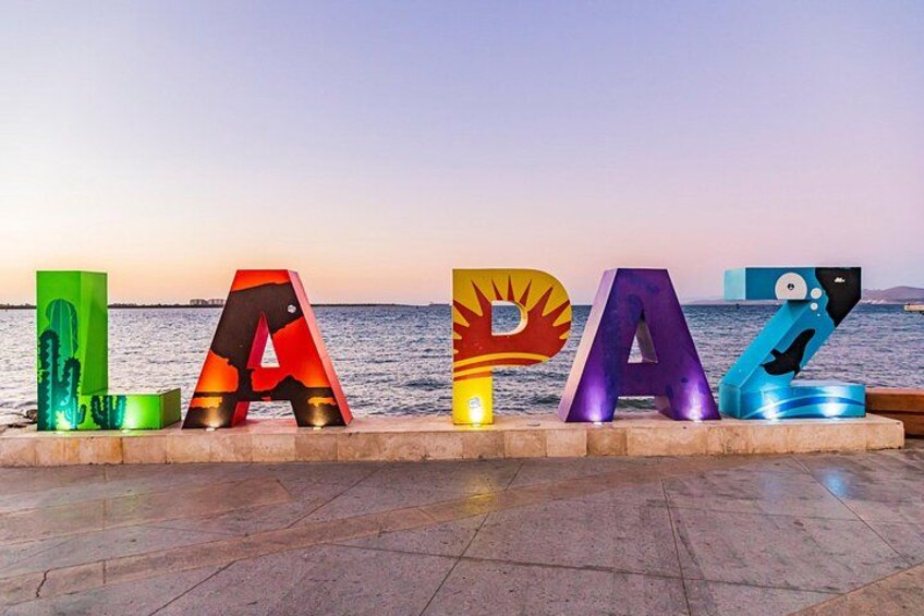 Large colorful letters spelling 'LAZ' on a waterfront promenade. 1