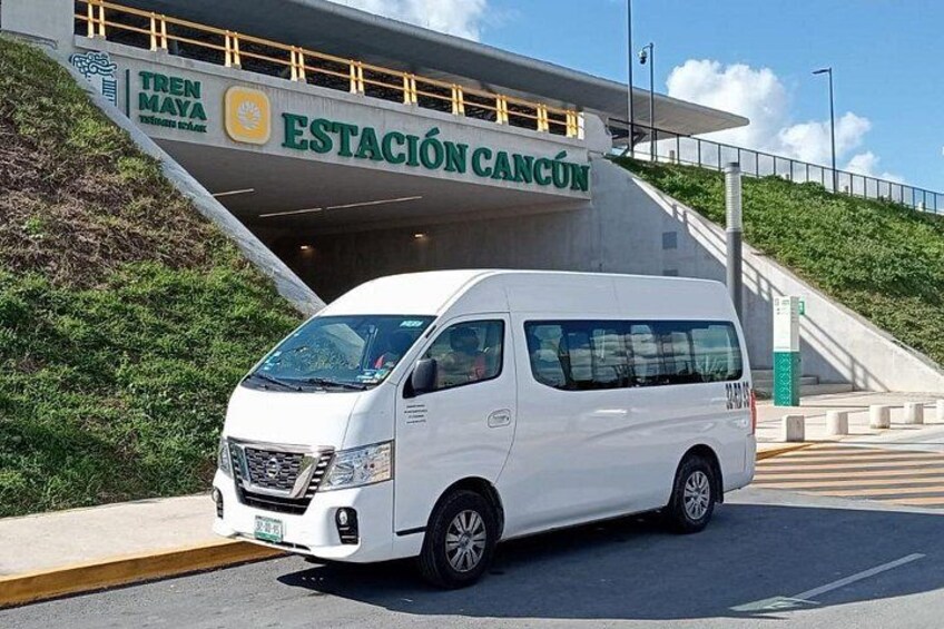 A white van parked in front of a station with a sign that reads 'ESTACIÓN CANCÚN'. 3