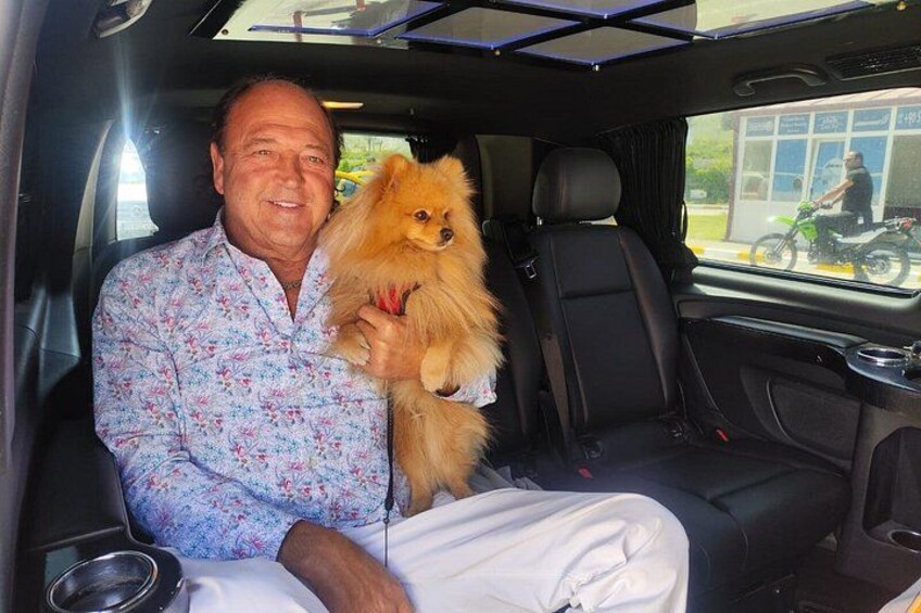 Ein Mann hält einen kleinen Hund im Auto. 4