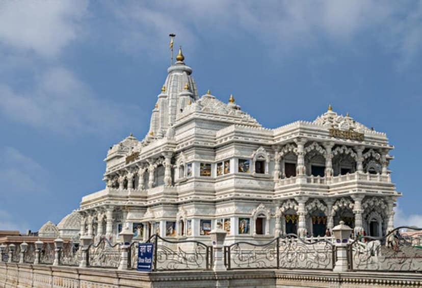 A white temple with intricate carvings and a spire. 1