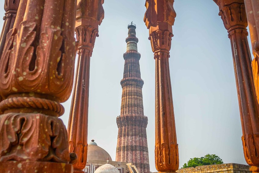 A historic tower with intricate carvings and a dome, framed by ornate columns. 3