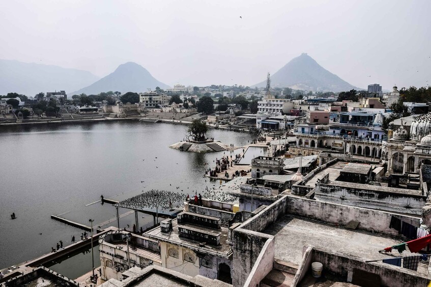 A riverside town with a prominent temple and mountains in the background. 5