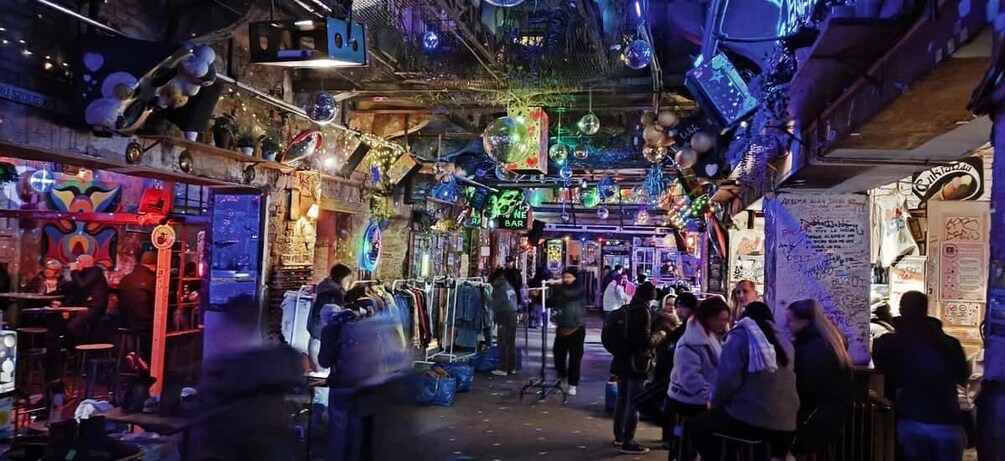A crowded indoor market with various stalls and hanging decorations. 5