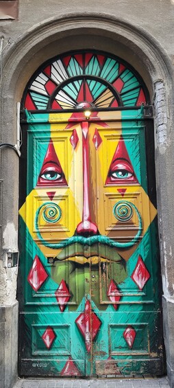 A colorful door with a face painted on it, featuring eyes and a nose. 4