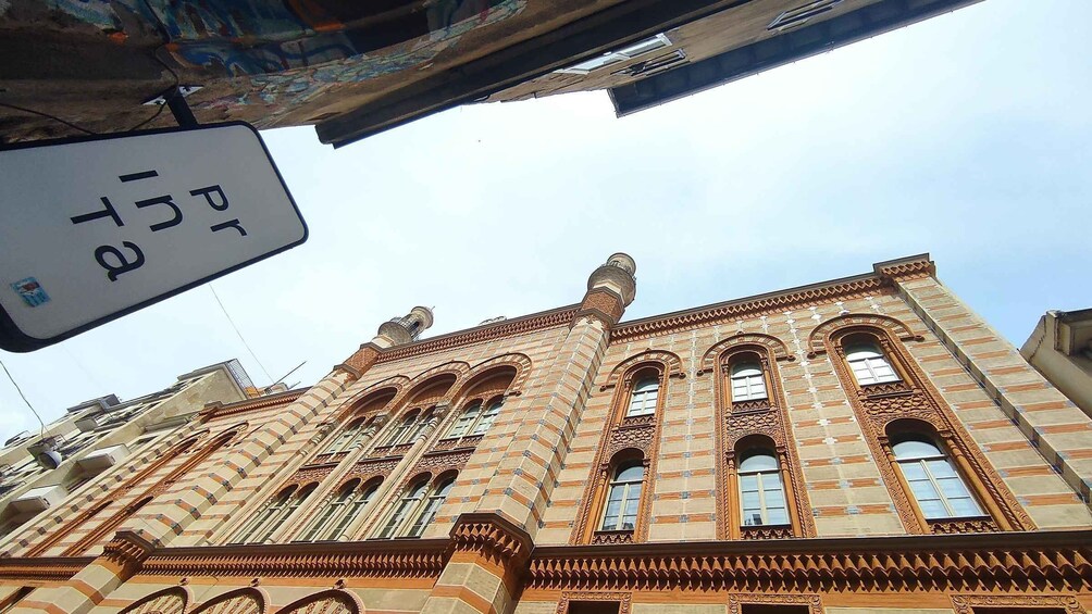 A building with intricate architectural details and a sign with Cyrillic text. 1