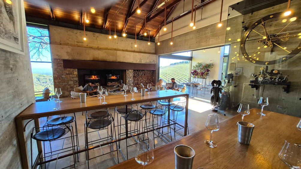 A rustic interior with a long bar, stone walls, and a fireplace. 4