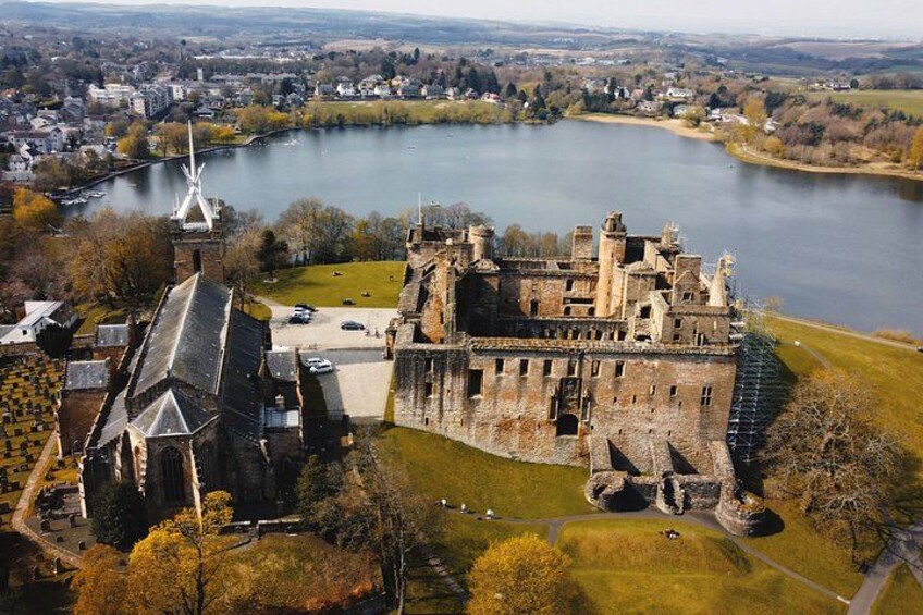 A castle by a lake with a church nearby. 1