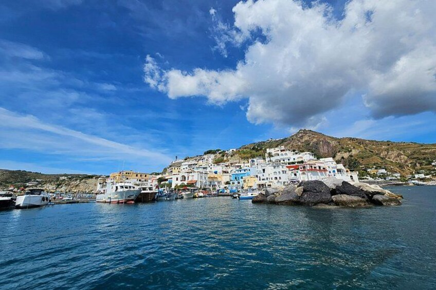 A coastal village with colorful buildings, boats, and a rocky island. 4