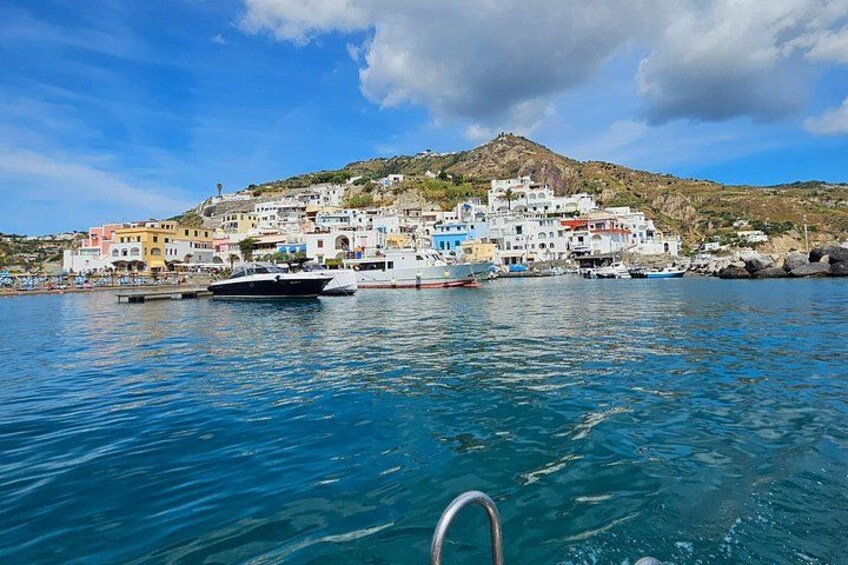 A coastal town with colorful buildings, boats, and a clear blue sea. 3