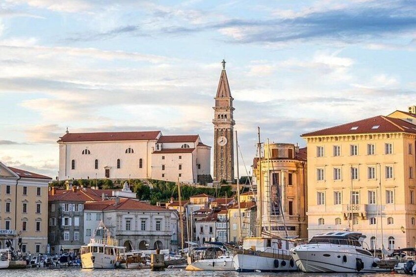 A harbor with boats, a clock tower, and historic buildings. 1