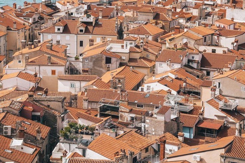 A densely packed urban area with numerous buildings featuring red-tiled roofs. 2