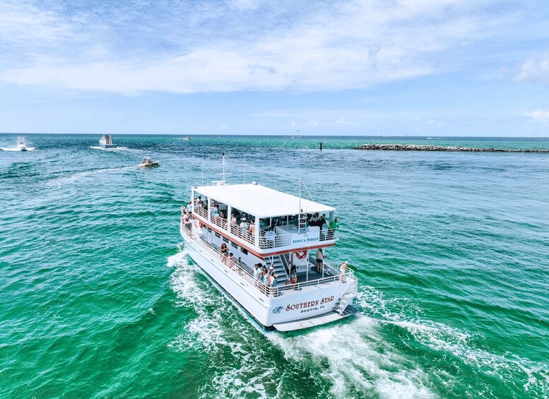 A large white boat named 'Southern Star' with passengers, sailing on turquoise waters. 2