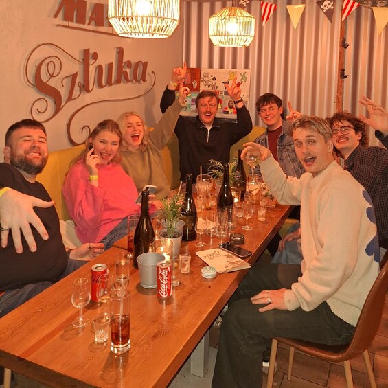A group of people sitting around a wooden table with drinks and a menu, in a room with a sign that reads 'Matsukawa'. 4