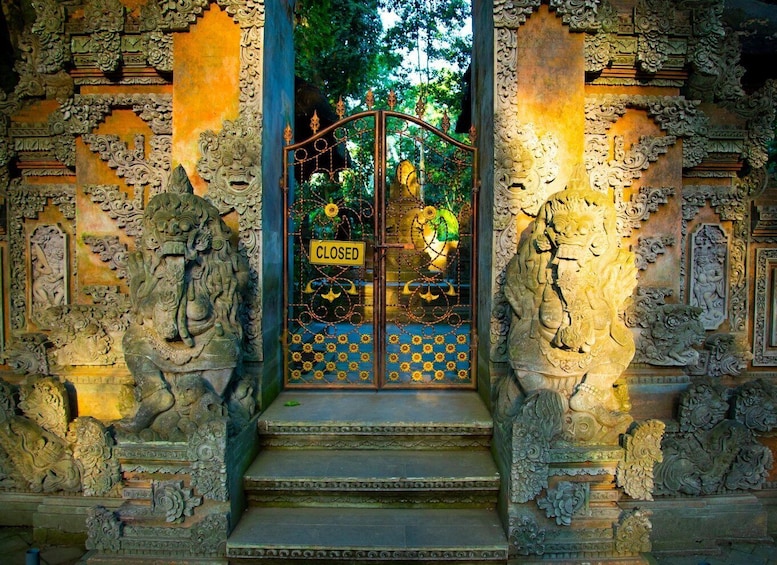 A closed gate with intricate carvings and a sign. 5