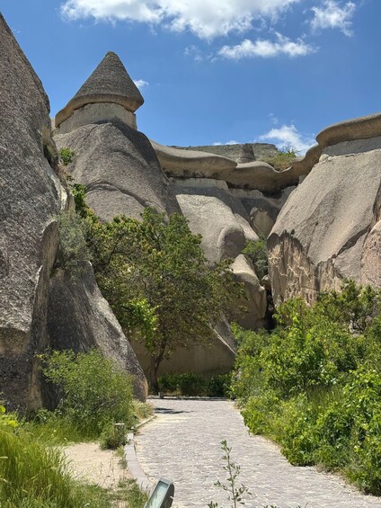 A rocky landscape with a paved path leading through a natural formation. 2