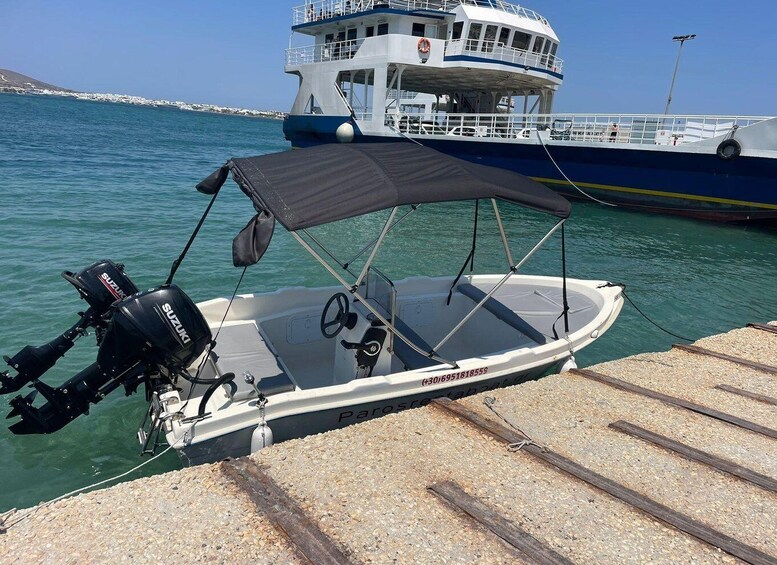 A small motorboat with a Suzuki outboard motor docked at a pier. 2