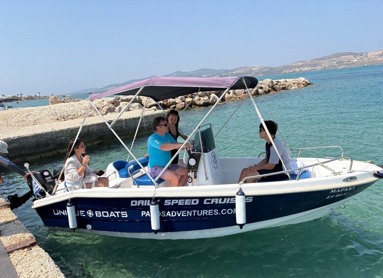 A boat named 'Mapaki' docked at a pier with clear turquoise water and rocky terrain in the background. 1