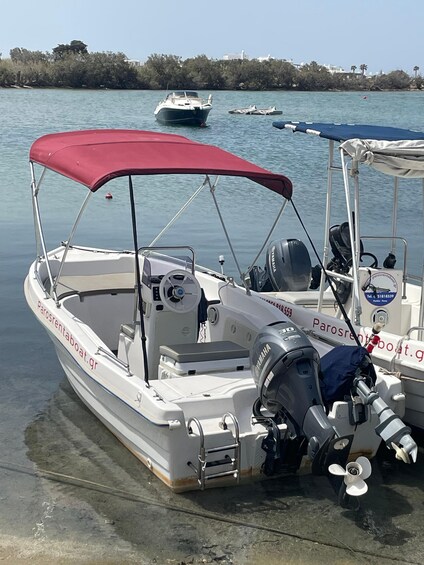 A white boat with a red canopy docked at a marina. 4