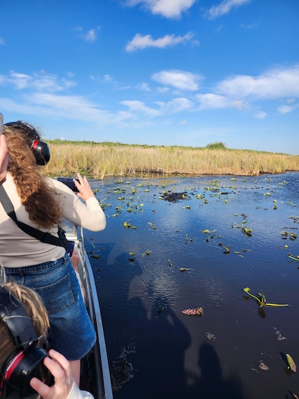 A person taking a photo of a water body with vegetation. 4