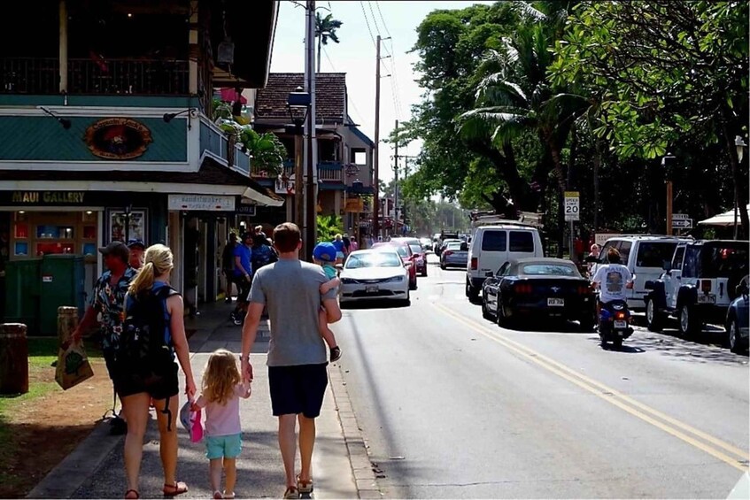 A street with pedestrians, parked cars, and a building with a sign reading 'Maui Gallery'. 5