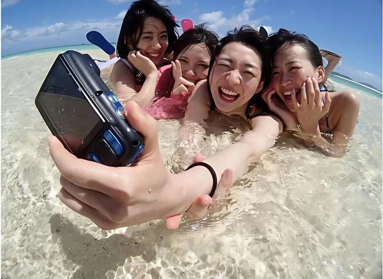 A group of people at the beach, taking a selfie with a smartphone. 3