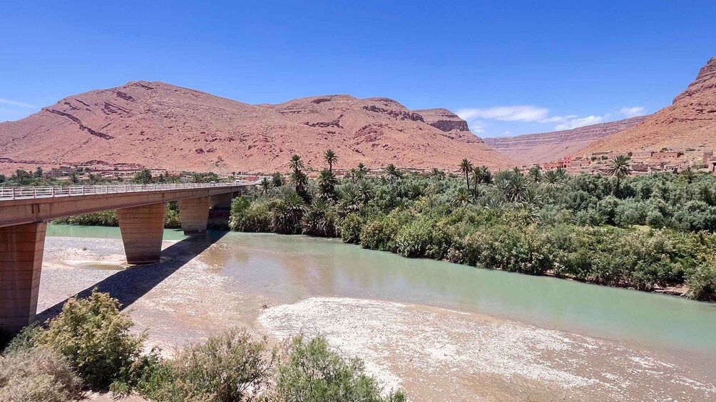 A bridge over a river with mountains in the background. 5