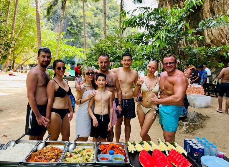 A group of people at a buffet with various food options and a tropical outdoor setting. 3