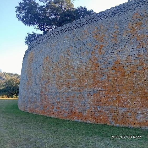 A large brick wall with a mix of red and grey bricks. 1