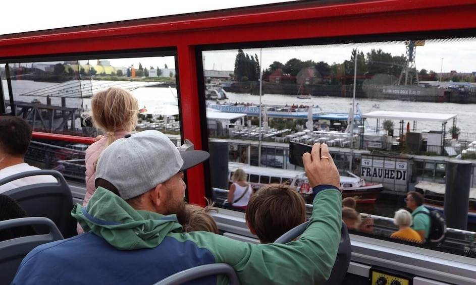 People on a boat, looking at a marina with boats and a bridge in the background. 4