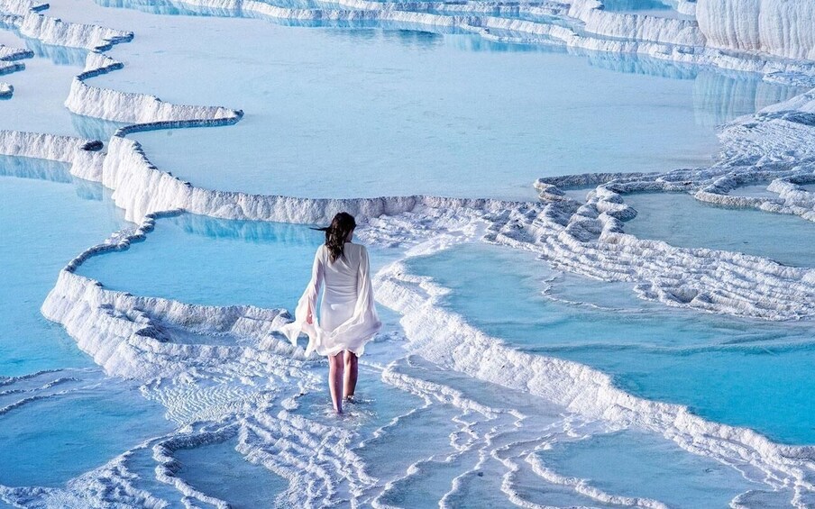 A person walking on terraced mineral formations. 1