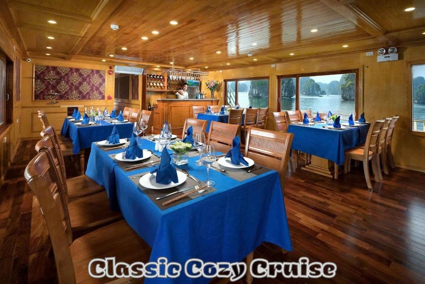 A cruise ship dining area with tables set for a meal, wooden floors, and a view of the water. 5