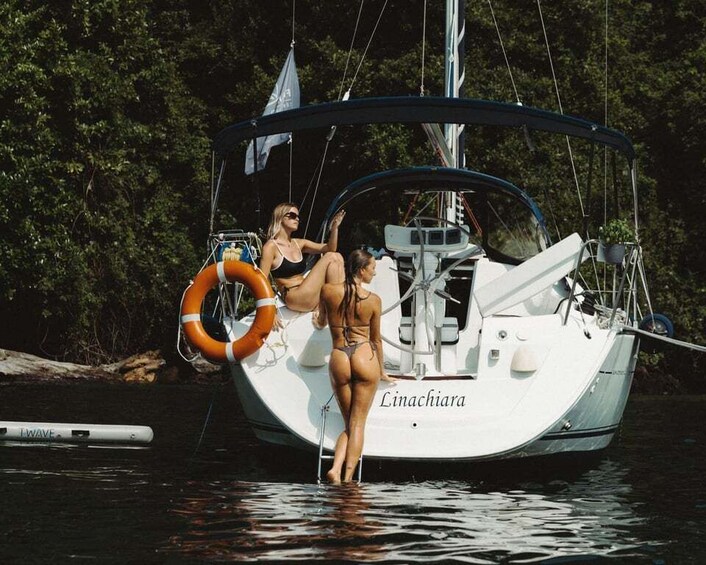 A sailboat named 'Linachiara' docked at a marina with two people standing on the deck. 1