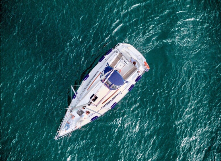 An aerial view of a sailboat on turquoise water. 2